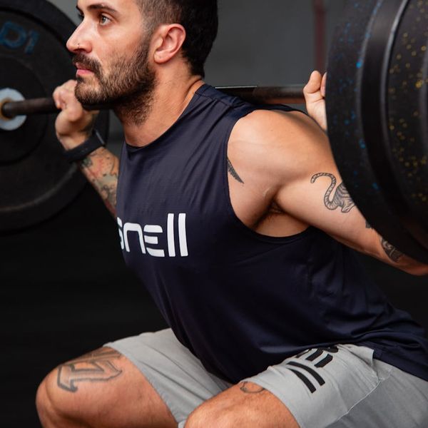 Focused man lifting weights with determination.